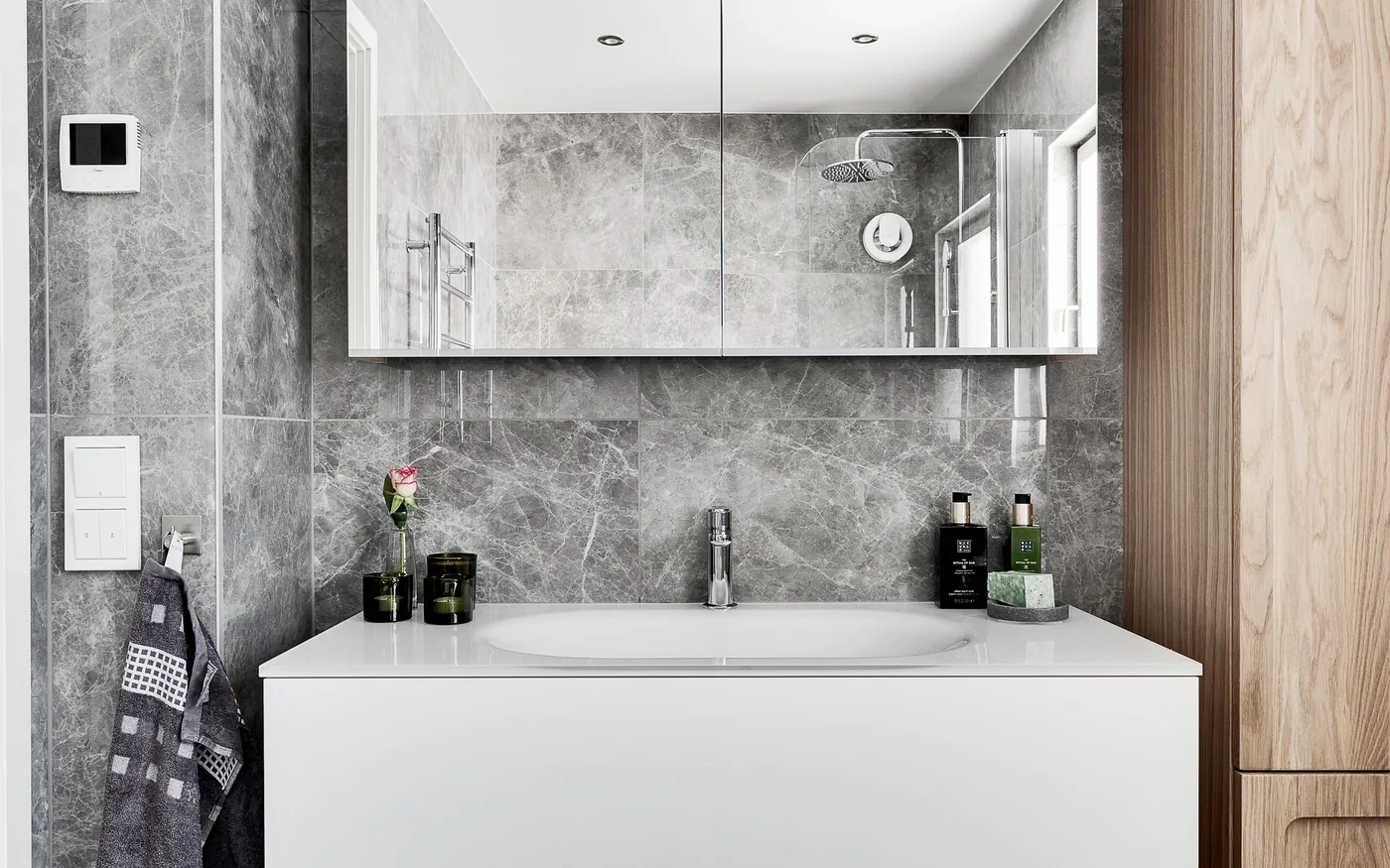 Beyaz lavabo altı banyo dolabı, üstünde aynalı dolap ve yanında ahşap kapaklı dar boy dolabı